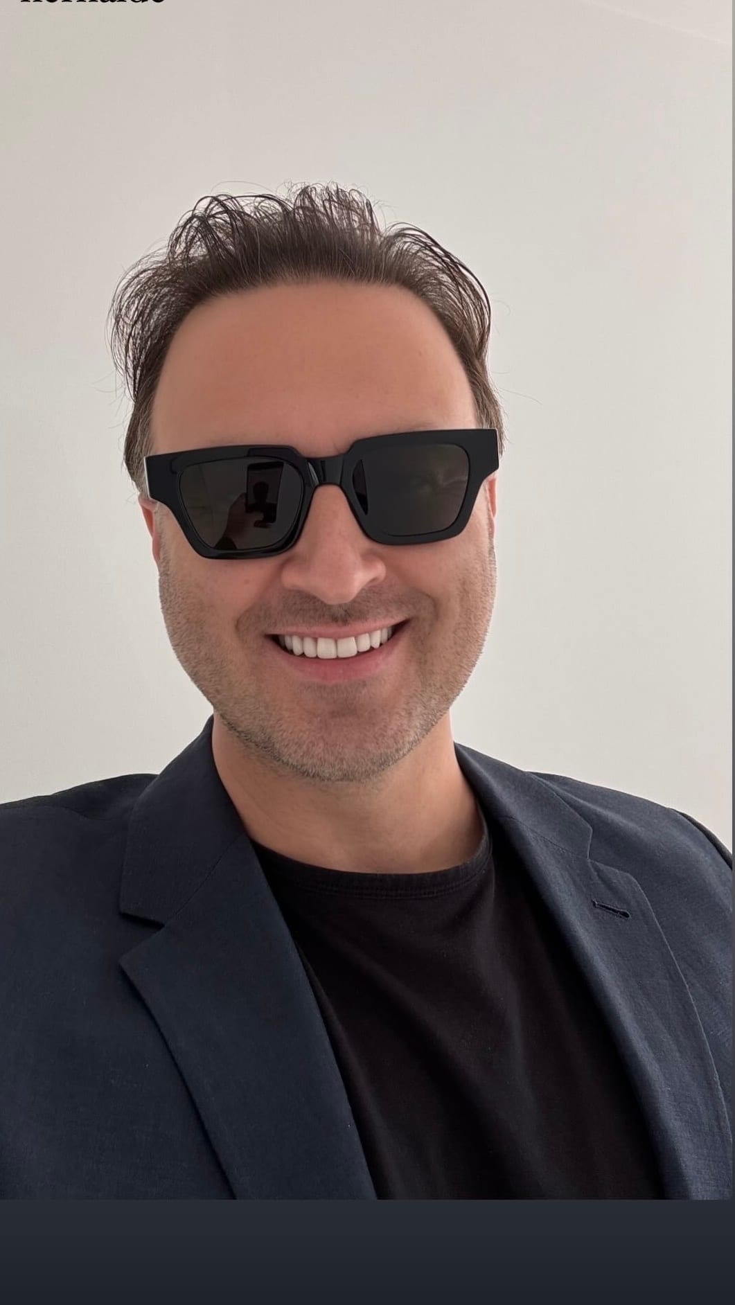 Serhat Gürcü smiling in sunglasses and a dark blazer